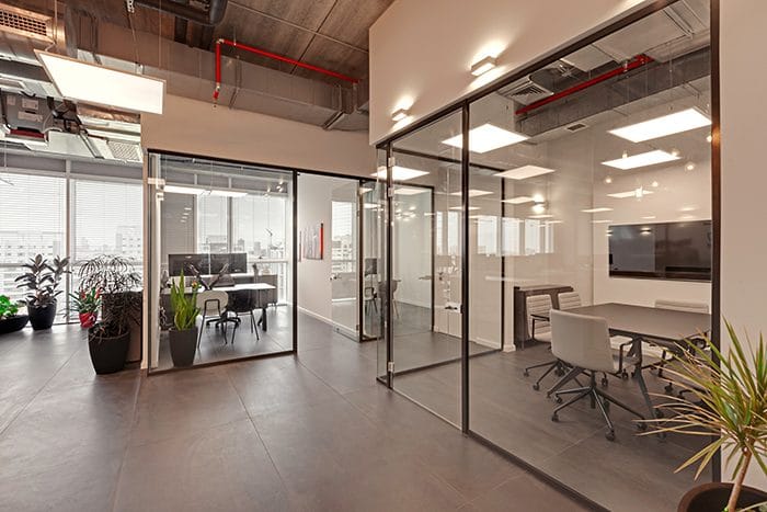 עיצוב חדרי עבודה שקופים במשרדים עם תקרה חשופה
