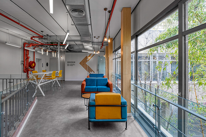 עיצוב כניסה למשרדים מבוסס על ביופיליה עם ריהוט צבעוני ופטיו